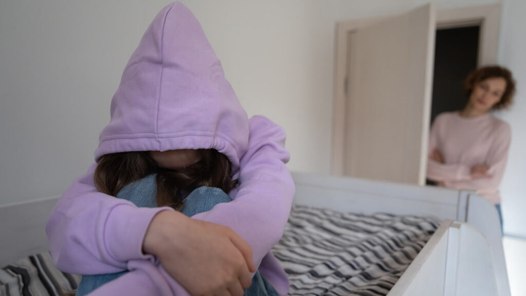 Image of an upset teenager in their bed while the parent stares at them from the door. Find yourself wondering "what is narcissistic abuse?" In our trauma blog we explain the effects of dealing with emotionally immature parents and narcissistic abuse. As one of the benefits of trauma therapy we can help you work through past experiences. Los Angeles 90210 | 90077 | 90272 | 
