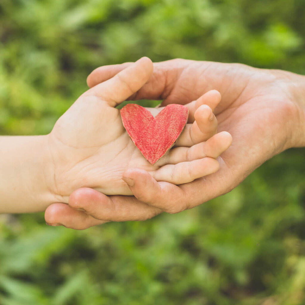 Image of an adult and kids' hands holding a paper heart. What does trauma-informed mean? Trauma-informed parenting can help you with understanding children. Get help with trauma therapy in Newark, NJ 07102 | Jersey City, NJ 07307 | Houston, TX 77002 | San Antonio, TX 24334
