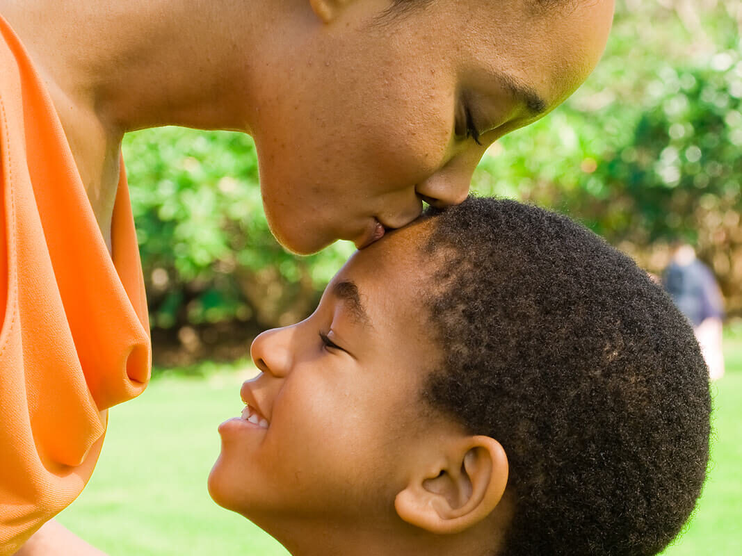 Mother kissing sons forehead. Understanding childhood trauma and helping your child healing from childhood trauma can help them in the long run. Find a skilled trauma therapist near me soon! Minneapolis, MI | Washington, DC 20012 | 20001 | Houston, TX 77002 | San Antonio, TX 24334